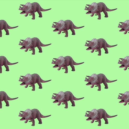Pattern of toy dinosaurs on a green background